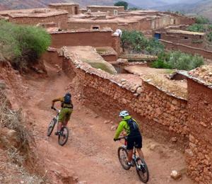 duas pessoas a andar de bicicleta numa estrada de terra batida em Tiki House Marrakech chez Paul em Lalla Takerkoust