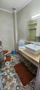 a bathroom with a sink and a large mirror at Lac et Désert Agafay Tiki House chez Paul in Lalla Takerkoust +53 photos