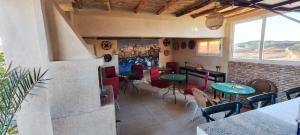 a restaurant with tables and chairs in a room at Lac et Désert Agafay Tiki House chez Paul in Lalla Takerkoust