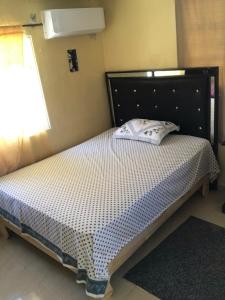 un lit avec une tête de lit noire dans une chambre dans l'établissement La hermosa hotel, à Santa Cruz de Barahona