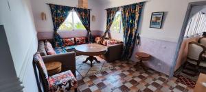 a living room with a couch and a table at Lac et Désert Agafay Tiki House chez Paul in Lalla Takerkoust