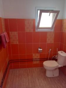 a bathroom with a toilet and a window at L'essentiel nianing in Mbour