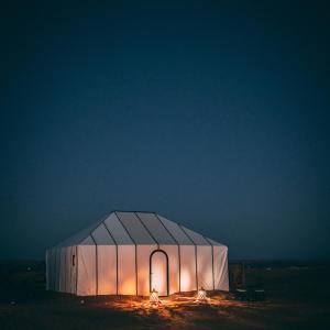 een tent verlicht in de nacht in de woestijn bij Merzouga Stars Luxury Camp in Merzouga