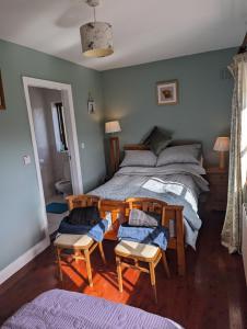 a bedroom with a bed and two chairs at Drummonds House in Sligo