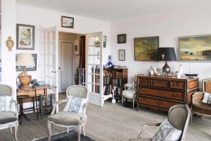 - un salon avec des chaises, une table et un bureau dans l'établissement Comfortable flat with view on the Eiffel Tower, à Boulogne-Billancourt