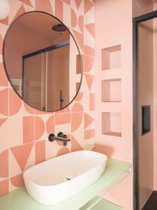 ein Bad mit einem Waschbecken und einem Spiegel in der Unterkunft Pop chic Suite a due passi dal centro in Genua