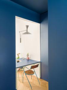 ein blaues Zimmer mit einem Tisch und einem Stuhl in der Unterkunft Pop chic Suite a due passi dal centro in Genua