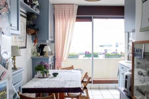 une cuisine avec une table et des chaises ainsi qu'une fenêtre dans l'établissement Comfortable flat with view on the Eiffel Tower, à Boulogne-Billancourt