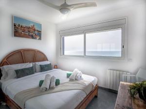 A bed or beds in a room at Marina Duplex by Hello Homes Sitges