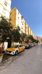 ein gelbes und weißes Auto, das an der Straßenseite parkt in der Unterkunft Apartments Relax in Valencia