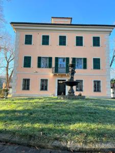 un grand bâtiment avec une fontaine devant lui dans l'établissement B&B Villa degli Aceri, à Carcare