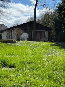 un champ d'herbe verte avec une maison en arrière-plan dans l'établissement B&B Villa degli Aceri, à Carcare