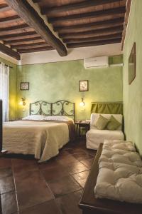 a bedroom with two beds and a couch in it at Meublè Evoè in Montepulciano