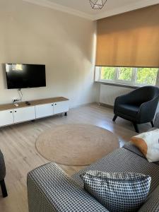uma sala de estar com um sofá e uma televisão de ecrã plano em Well Hotel Edirne em Edirne