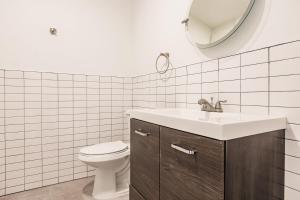 a bathroom with a toilet and a sink and a mirror at Aerie Apartments in Miami +12 photos