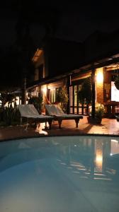 una piscina por la noche con un banco junto a un edificio en Finca PANACA Jagüey 12 VIP Group - Villas for Rent in, en Quimbaya
