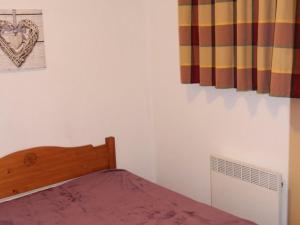- une chambre avec un lit doté de draps et de rideaux violets dans l'établissement Appartement Valfréjus, 4 pièces, 8 personnes - FR-1-265-185, à Valfréjus