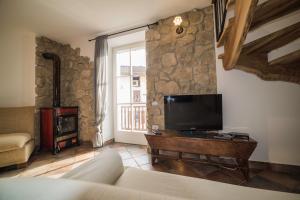 a living room with a couch and a tv at Casa Celeste Ledro in Ledro
