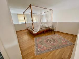Habitación con cama con dosel y alfombra. en Cityloft Gold - Zentrum / 105qm / inkl. Parkplatz / Netflix, en Leipzig