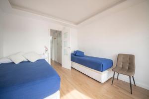 um quarto com uma cama azul e uma cadeira em Apartamento en Calella a 7 minutos de la playa em Calella