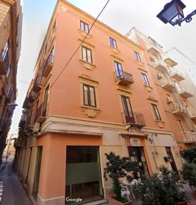 ein großes orangefarbenes Gebäude an einer Stadtstraße in der Unterkunft La Mattanza in Trapani