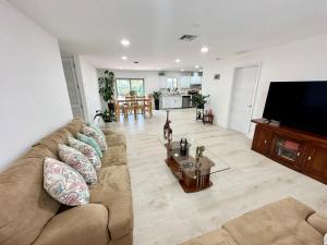 a living room with a couch and a tv at Good Vibes House with private pool in Dania Beach
