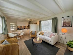 ein Wohnzimmer mit einem Sofa und einem Tisch in der Unterkunft New- Private Cosy Houseboat, on a lake near Amsterdam in Vinkeveen