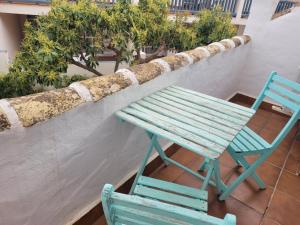 a green bench and a blue chair on a balcony at Beach House Casa Luna, Calahonda Marbella, Mijas Costa in Sitio de Calahonda