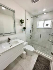 a bathroom with a sink and a toilet and a shower at Good Vibes House with private pool in Dania Beach