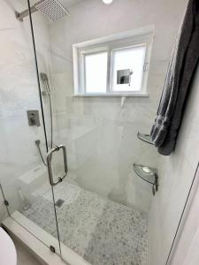 um chuveiro com uma porta de vidro na casa de banho em Good Vibes House with private pool em Dania Beach