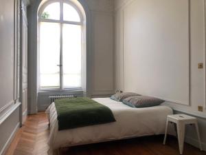 a bedroom with a bed with a large window at Magnifique Appartement dans palace Belle Époque in Aix-les-Bains