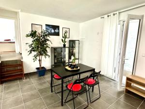 a dining room with a black table and red chairs at Sweet Dream House in Brussels