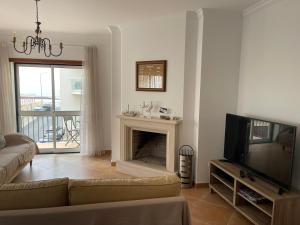a living room with a couch and a television at Casa dos Pexins in Nazaré +46 photos