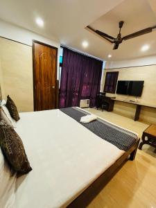 1 cama blanca grande en una habitación con TV de pantalla plana. en Hotel Satwah Home Stay, en Nueva Delhi