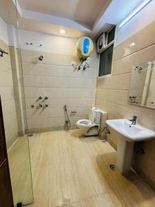 uma casa de banho com um chuveiro, um WC e um lavatório. em Hotel Satwah Home Stay em Nova Deli