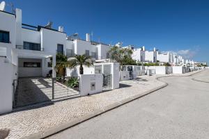una fila di appartamenti bianchi su una strada di Villa Conchas by Algarvemanta a Manta Rota