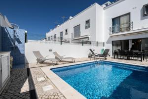 una piscina con sedie accanto a un edificio di Villa Conchas by Algarvemanta a Manta Rota