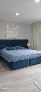 a bedroom with a bed with a blue comforter at Pinneapple Studio in Ponta Delgada