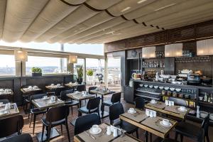 a restaurant with tables and chairs and a bar at The Independent Hotel in Rome