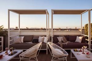 d'une terrasse avec un canapé et des chaises sur un balcon. dans l'établissement The Independent Hotel, à Rome