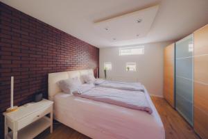 a bedroom with a brick wall and a bed at Smart Luxury - Private Gym, Hot Tub & Sauna in Keflavík