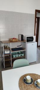 a kitchen with a microwave and a table with plates at Zinexium in Gignese