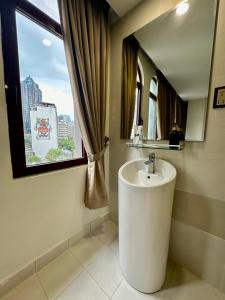 a bathroom with a sink and a window at Swing & Pillows - KL Masjid India formerly known as Mountbatten Hotel Kuala Lumpur in Kuala Lumpur