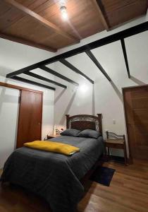 a bedroom with a bed with a yellow pillow on it at Casa de campo - Fundo El Alisal in Cajamarca