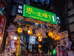 una calle de la ciudad por la noche con señales y luces en APA Hotel Higashi Shinjuku Kabukicho en Tokio