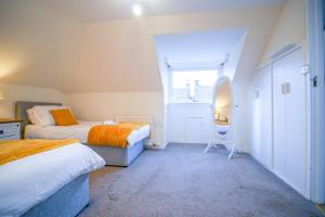 um quarto com 2 camas e uma janela em Lochlash 3 Bedroom House Inverness em Inverness