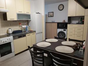 uma cozinha com uma mesa com cadeiras e um balcão em Apartman Zenica em Zenica