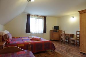 a bedroom with a bed and a table and a window at Pensiunea Aries in Arieşeni