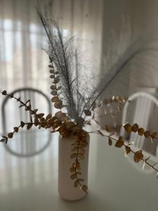 a white vase with some dried flowers in it at La Madriguera de Toledo in Bargas