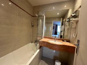 a bathroom with a sink and a shower and a tub at Hôtel France Eiffel in Paris